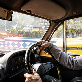 A person is shown driving from the inside of a vehicle alongside text about "rolling out a fleet of 100% electric vehicles." 