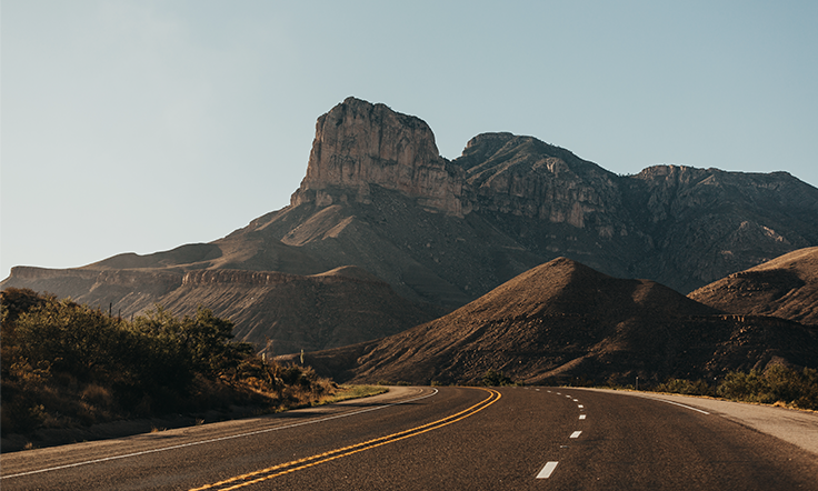 A desert landscape is shown in the distance in front of an open road alongside text about "patnering to decarbonize transportation." 