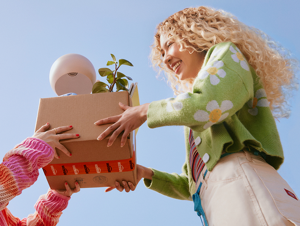 A person hands a box of items to another person.