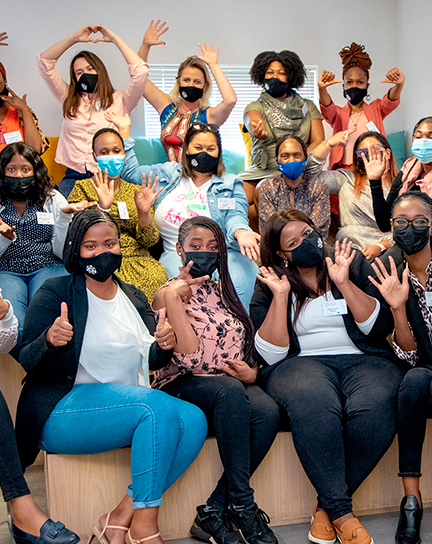 A group of people wearing masks pose smiling.